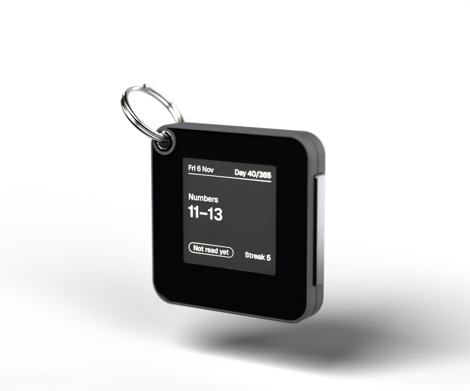 PressOn, a graphite square with an e-ink screen showing today’s reading, Numbers 11 to 13, on a steel split ring